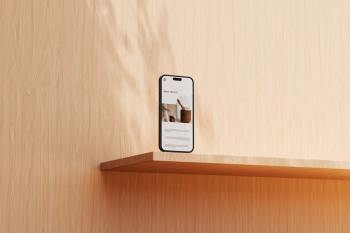Upright smartphone display mockup on a light oak shelf with soft leaf shadow overlays.
